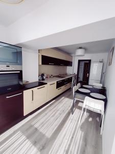 a kitchen with a table and a dining room at Happy Blue Apartament in Galaţi +11 photos