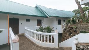a white house with a green roof at RedDoorz at Garvs Boutique Hotel Boracay in Boracay