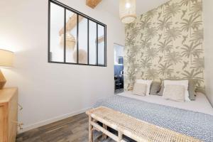 a bedroom with a bed and a wall with palm wallpaper at Saint Tropez - Old Village - Modern & Cosy Apartments in Saint-Tropez
