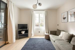 a living room with a couch and a tv at L'ATELIER 2 - Vintage KEYWEEK downtown Biarritz Centre in Biarritz