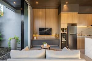 ein Wohnzimmer mit Couch und Küche in der Unterkunft Private Villa Ayra 8E by OriVista 10min to Melasti Beach in Uluwatu