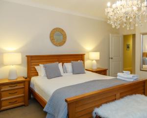 - une chambre avec un lit, deux lampes et un lustre dans l'établissement Heartbeat Retreat - Luxury Estate with Gym & Sauna, à Dunsborough 73 autres photos