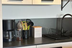 una encimera de cocina con utensilios en un contenedor en T2 vue mer climatisé wifi & refait à neuf idéalement situé à Ajaccio, en Ajaccio