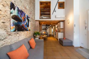 a living room with a couch and a stone wall at Happy People Ramblas Harbour Apartments in Barcelona