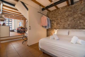 バルセロナにあるハッピー ピープル ランブラス ハーバー アパートメンツのベッドと石の壁のある寝室