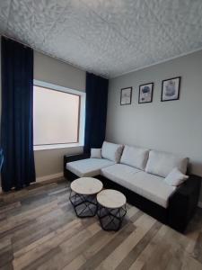 a living room with a couch and two tables at 722 Slate Apartament Jedlina-Zdrój in Jedlina-Zdrój