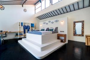 a bedroom with a large white bed and stairs at Stay Shark Villas Gili Air in Gili Islands