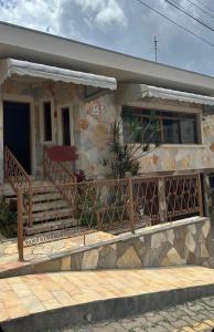 a stone house with a porch and a balcony at ALAMEDA iNN in Poços de Caldas
