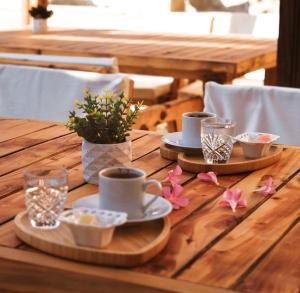 a wooden table with cups and plates and flowers on it at Orya Butik Otel in Side