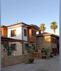 a brick house with palm trees in the background at Orya Butik Otel in Side