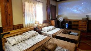 バギオにあるFamily Room 1A Transient Baguio Parking Wifiのベッドが2つと大きな窓がある寝室 +11枚の写真