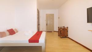 a bedroom with a white bed and a wooden floor at RedDoorz at Garvs Boutique Hotel Boracay in Boracay