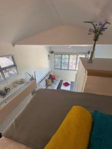 una habitación con una cama con una manta amarilla en Hillside Tiny House, en Knysna