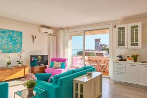 Garda Blue Lake Home Luxury Appartment في ديسينسانو ديل غاردا: غرفة معيشة مع أريكة زرقاء وكراسي وردية +50 صورة