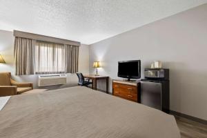 a hotel room with a bed and a flat screen tv at Quality Inn near Monument Health Rapid City Hospital in Rapid City