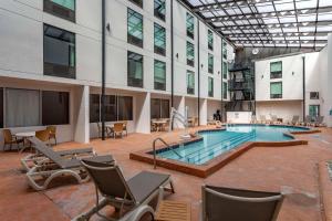 a large pool in a building with chairs and a building at Comfort Inn & Suites Nashville Downtown - Stadium in Nashville