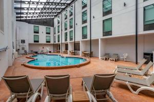 a large pool in a building with chairs around it at Comfort Inn & Suites Nashville Downtown - Stadium in Nashville