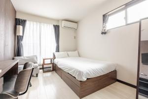 una piccola camera da letto con un letto e una finestra di アンドステイ竹ノ塚201 a Tokyo