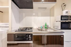 una cucina con lavello e microonde di アンドステイ竹ノ塚201 a Tokyo