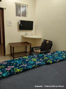 a bedroom with a bed and a desk and a computer at Adithya Inn Lodge in Jadcherla