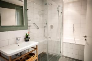a bathroom with a sink and a shower at Luxury City Suite - Rosenheim in Rosenheim +43 photos