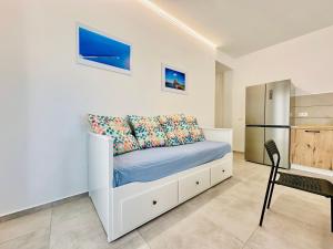 a white bedroom with a bed and a refrigerator at Sea Life Giulia, spiaggia a 200 mt in Alcamo Marina +23 photos