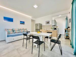 a kitchen and a living room with a table and chairs at Sea Life Giulia, spiaggia a 200 mt in Alcamo Marina