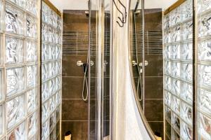 La salle de bains est pourvue d'une douche et de portes en verre. dans l'établissement Sol y Duna, à Palamós