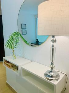 una lámpara en una mesa blanca con un espejo en The Best View in Brisas Marques, en Acapulco