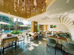 a restaurant with tables and chairs and a pool at Remember Vangvieng Hotel in Vang Vieng