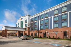 弗赖拉辛Comfort Inn & Suites Frisco East - McKinney的停在建筑物前的汽车