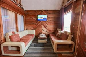 KejajarにあるBatu Lawang Sikunir By Travelinkのソファ、椅子2脚、テレビが備わる客室です。