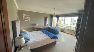 a bedroom with a bed and a large window at Sunset Retreat in Cape Town
