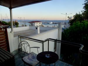 a balcony with a table and chairs and a view of a harbor at Sarissa Butik Otel in Ayvacık