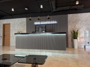 a lobby with a table and a sign on a wall at NBG d 'amore Appart in Batumi