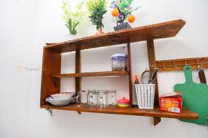 KejajarにあるBatu Lawang Sikunir By Travelinkの壁に掛けられた調理器具が置かれた木製の棚