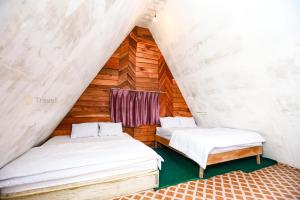 KejajarにあるBatu Lawang Sikunir By Travelinkの木製の壁の部屋にベッドが2つある