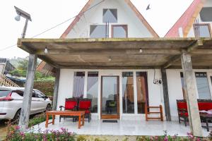 KejajarにあるBatu Lawang Sikunir By Travelinkの木造屋根の小さな白い家