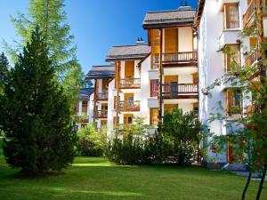 a row of apartment buildings with a green yard at Stylish apartment with hotel spa in Lenzerheide