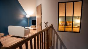 een kamer met een trap met een stoel en een slaapkamer bij Evaziona in Blairville