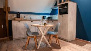 een kleine keuken met een tafel en 2 stoelen bij Evaziona in Blairville
