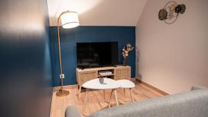 een woonkamer met een bank en een tv bij Evaziona in Blairville