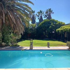 a swimming pool in a yard with palm trees at Sunset Retreat in Cape Town