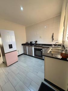 a large kitchen with a refrigerator and a sink at Pumuzika in Livingstone
