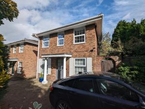 a car parked in front of a brick house at Spacious 4 Bed Gem near East Croydon Station in South Norwood