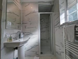 a white bathroom with a sink and a shower at Spacious 4 Bed Gem near East Croydon Station in South Norwood +10 photos