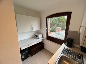 a small kitchen with a sink and a window at Monteure und Pendler willkommen! Komfortable 2 Zimmer Apartments in der Innenstadt in Neumünster