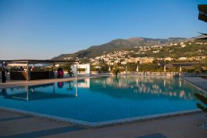 a large swimming pool with a city in the background at Grand Hotel Moon Valley in Vico Equense