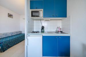 a small kitchen with blue cabinets and a sink at Studio hypercentre gare in Nice +6 photos