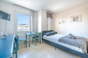 a bedroom with a bed and a desk and a window at Studio hypercentre gare in Nice
